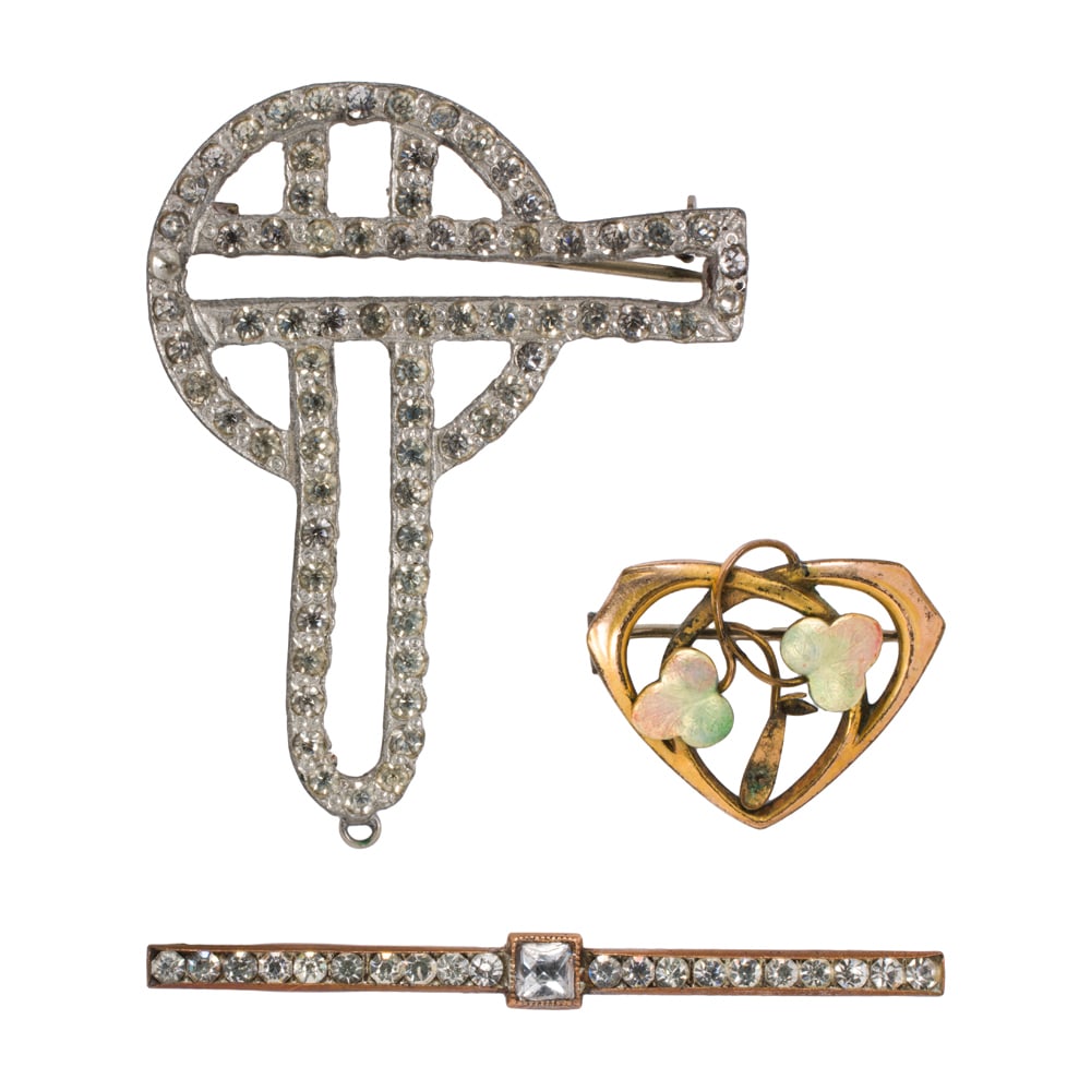 Three antique pins: Three antique pins Featuring an Art Nouveau enamel decorated floral heart-form pin, together with two Art Deco pins; gross weight: 16.00 grams