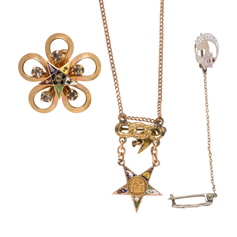 A group of gold tone jewelry: A group of gold tone jewelry Comprising two fraternal pins and one necklace, including a gold-tone flower-shaped Order of the Eastern Star brooch, A Daughters of Rebekah lapel pin for members of the