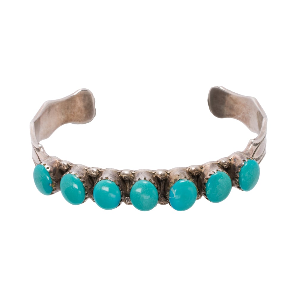 A PD Coonsis turquoise and sterling silver cuff bracelet: A PD Coonsis turquoise and sterling silver cuff bracelet Set with seven oval-shaped turquoise cabochons measuring 8.00 x 6.47 mm; length: 5 in; 18.55 grams