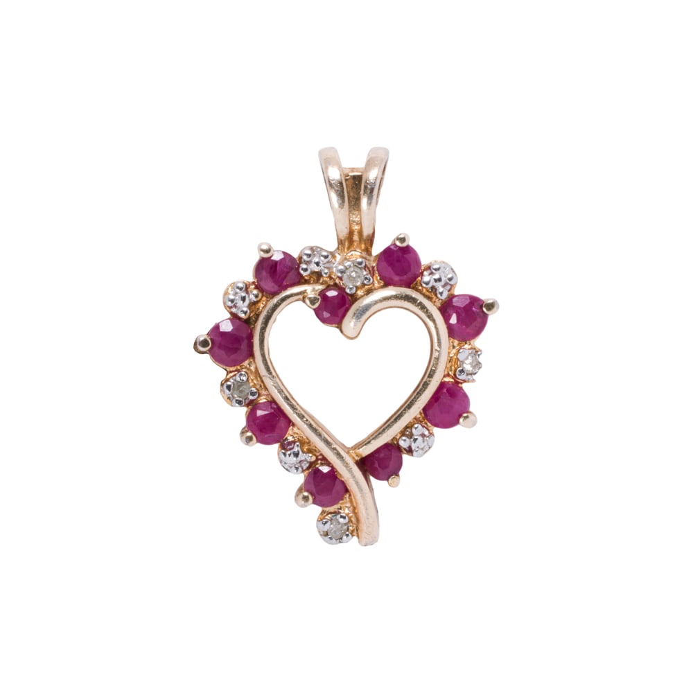 A ruby, diamond, and sterling silver pendant necklace: A ruby, diamond, and sterling silver pendant necklace The pendant designed as a heart, set with nine round-cut rubies and four round-cut diamonds; 2.30 grams