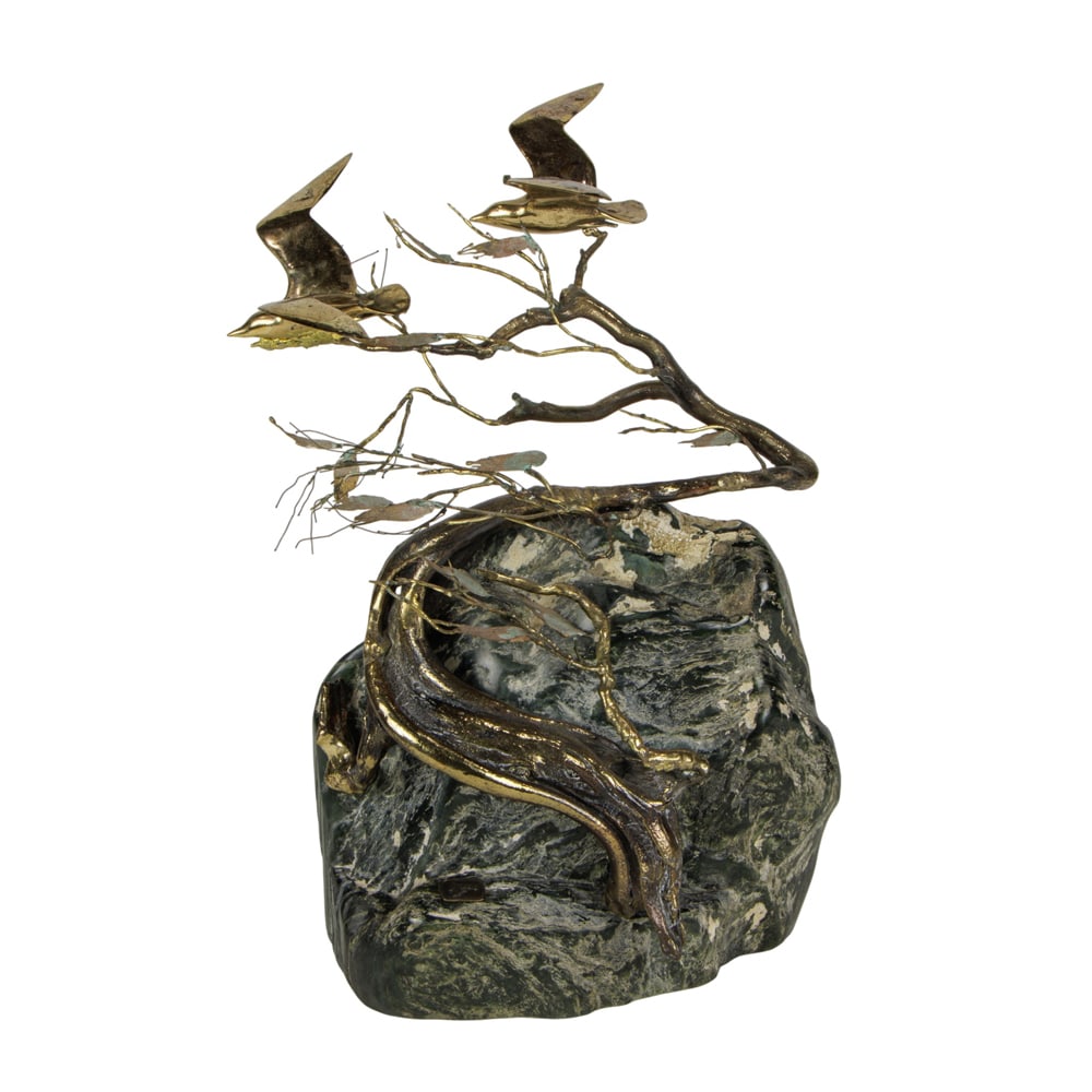 A Brutalist welded metal and stone group: A Brutalist welded metal and stone group, circa 1970, depicting birds in flight over a windswept tree on boulder, applied plaque, 14.75"h