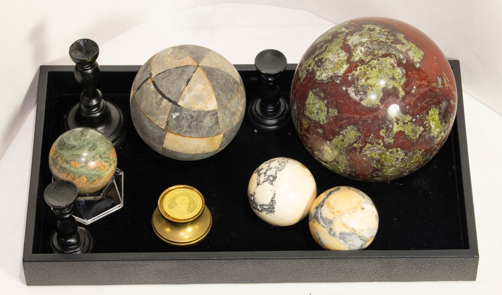 A collection of five stone spheres including a large bloodstone: A collection of five stone spheres including a large bloodstone, a tessellated black and white checkered stone, with associated stands, together with a commemorative coin of the tomb of Giuliano de