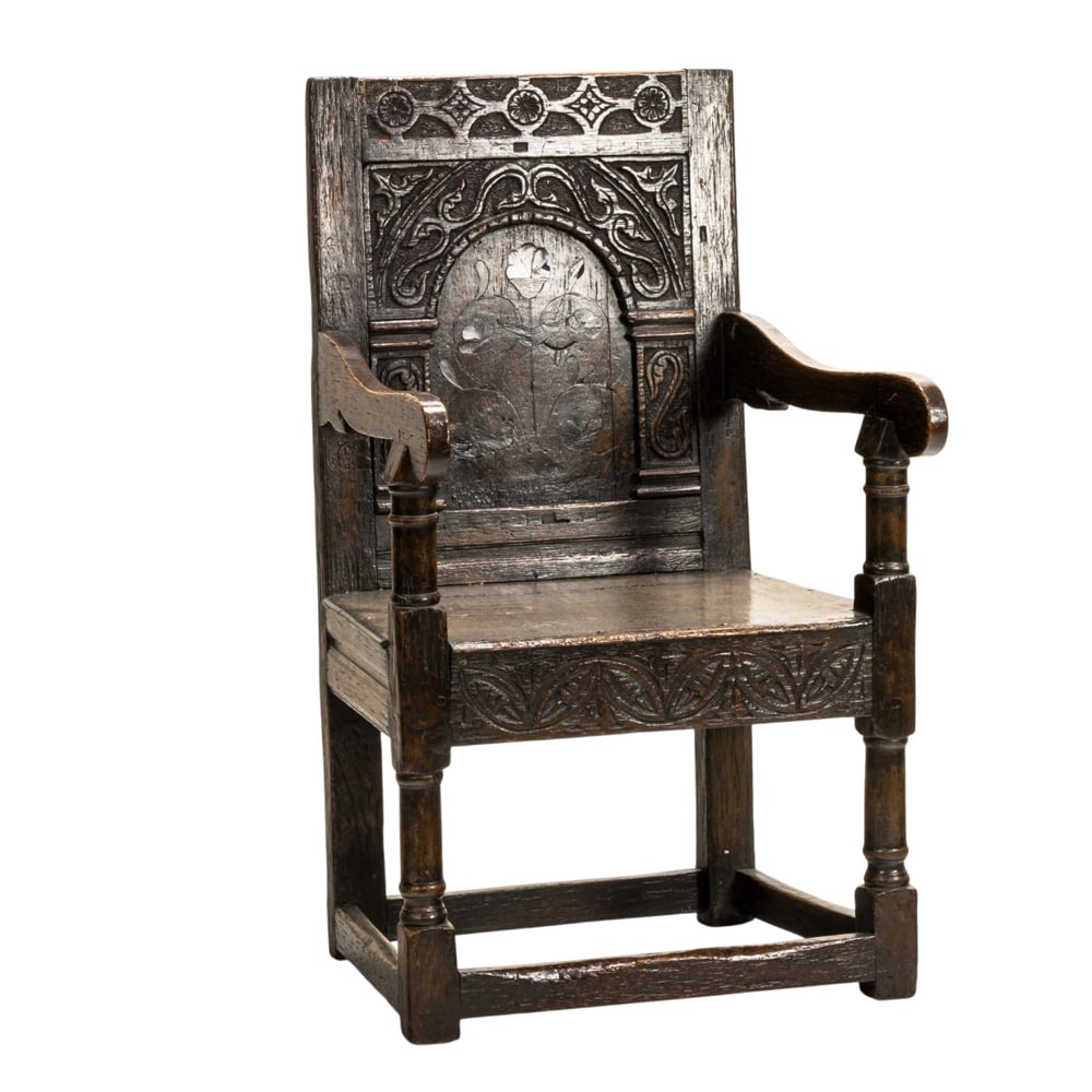 An English Charles I carved and inlaid wainscot chair: An English Charles I carved and inlaid wainscot chair, the period form in oak with an inlaid central panel and carved surround, and rising on block and turned legs, 40"h x 23"w x 18"d