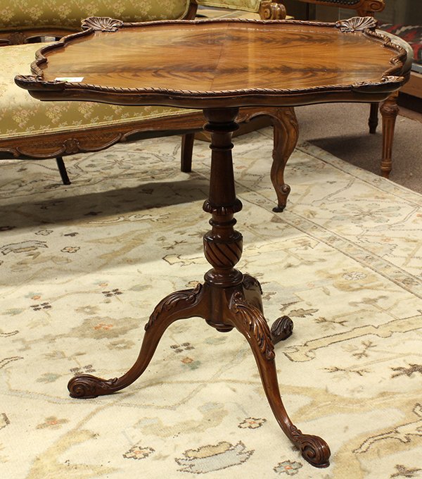 Rococo style tilt-top center table: Rococo style tilt-top center table, having a scalloped top with shell accents above the pilaster form standard and rising on a tripod base terminating on acanthus carved feet, 27.5"h x 25.5"w