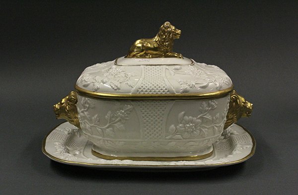 Italian creamware tureen: Italian creamware tureen, the cover centered by a recumbent lion final, above the base flanked by lion's mask handles, and having a conforming undertray with a floral motif and gilt accented border, b