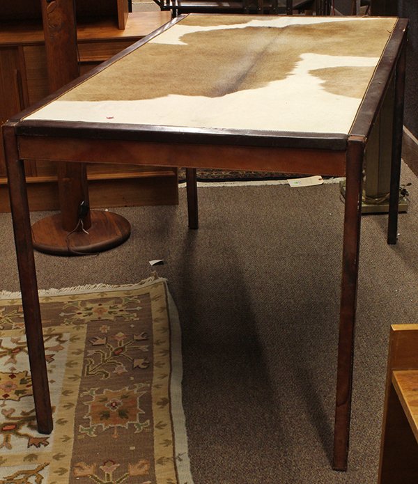 Leather and hide covered desk: Leather and hide covered desk, having a rectangular top covered in cream and brown cowhide banded in dark tanned leather, rising on leather wrapped square legs, 29"h x 51"w 28"d.