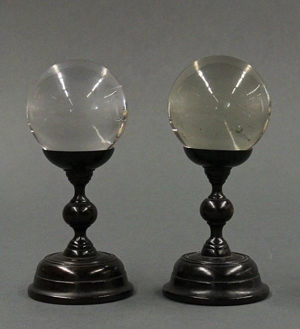 Two Rock Crystal Balls: (lot of 2) Rock crystal spheres, the translucent matrix with minor inclusions, with a wood stand, larger sphere: 2.5"dia