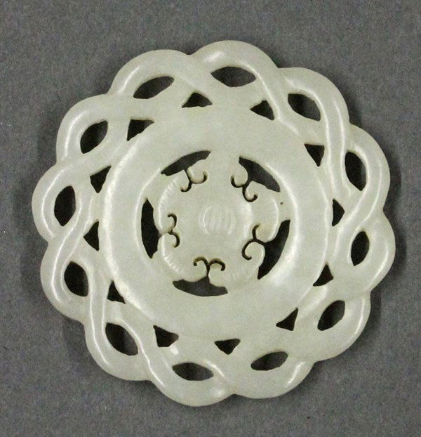 Chinese Jade Floral Roundel: Chinese jade medallion, reticulated with twisted strands framing a floral roundel, the pale matrix with icy inclusions, 2.125"w