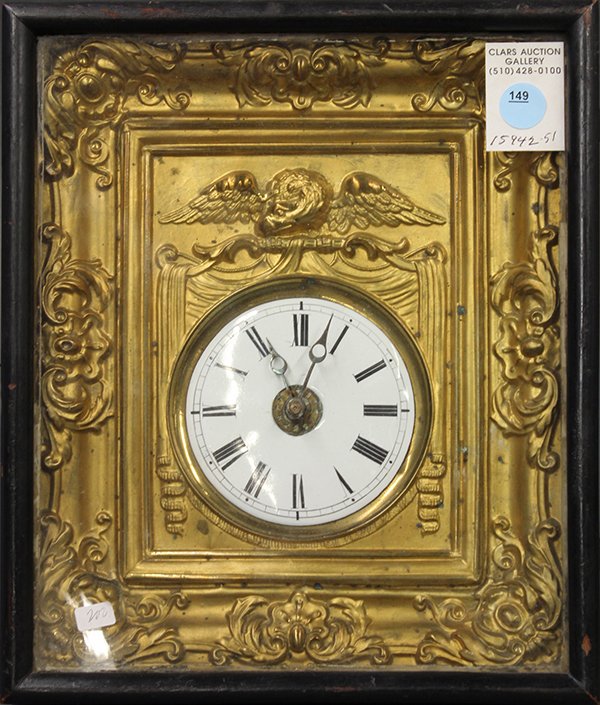 West German battery powered clock: West German battery powered clock, the enamel dial with Roman numerals housed in a gilt metal frame and mounted in an ebonized shadowbox, 11.25"h x 9.75"w