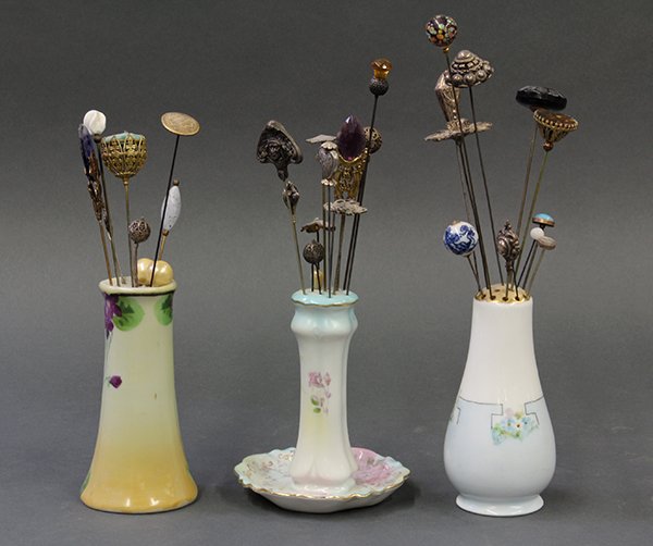Polychrome porcelain hat pin holders: (lot of 34) Three polychrome porcelain hat pin holders, one by Nippon, largest: 5.5"h; together with 31 Art Deco style hat pins