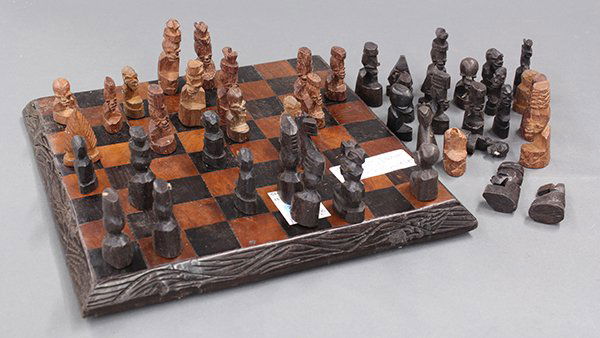 Chess board: Chess board with mahogany and ebony chess pieces carved to resemble African sculptures, 11.5"sq.