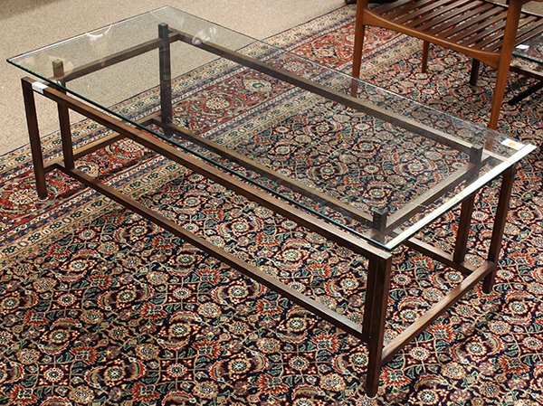 Moderne glass top tables: (lot of 2) Moderne glass top tables, the rectangular top coffee table floats above the offset open framing of the rosewood base, table: 17"h x 48"l x 22"d. together with a conforming occasional table 
