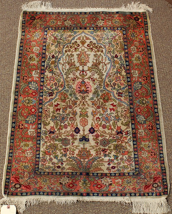 Turkish silk prayer rug: Turkish part silk prayer rug, circa 1900, having a tree of life mihrab with all over floral motifs, pale spandrels and an alternating rosette border on a pink ground, having woven signature upper righ