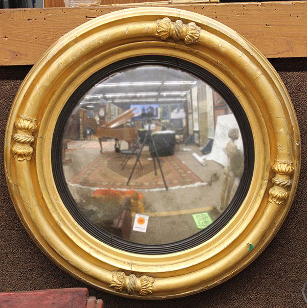 Continental giltwood carved convex mirror: Continental giltwood carved convex mirror, circa 1800, the molded border with acanthus reserves flanking the ebonized liner surrounding the convex looking glass, 29"w