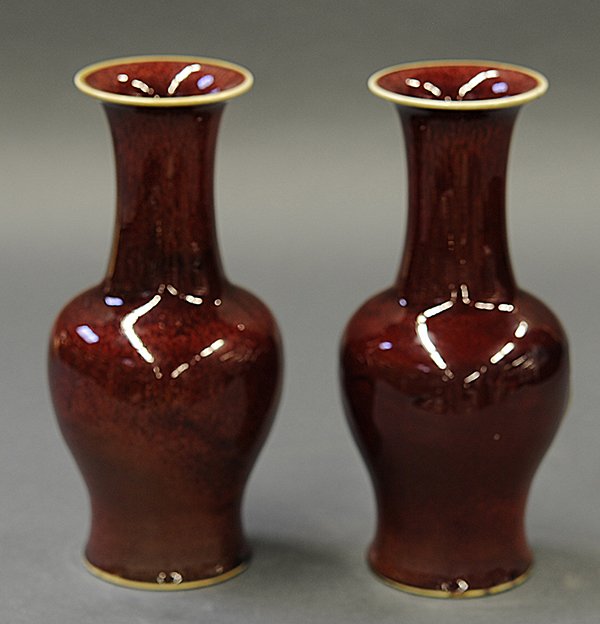 Chinese Ox Blood Porcelain Vases: (lot of 2) Chinese ox blood porcelain vases, everted white rim above the long neck and tapering body, 9"h