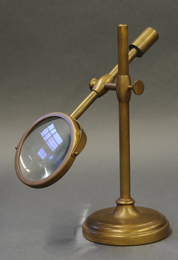 Antique style magnifying glass: Continental magnifying glass on an adjustable brass stand and rising on a circular base, 9"h