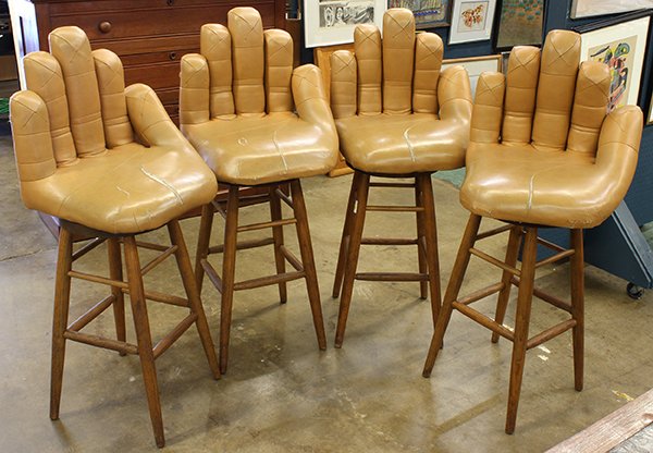 (lot of 4) Moderne figural "glove" bar stools: (lot of 4) Moderne figural "glove" bar stools, each in the form of a cupped left hand, the back in the form of the fingers, the seat a palm, rising on oak tapered legs, 48"h x 18"w x 18"d