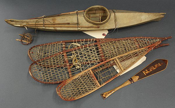 Group of Alaskan authentic native items: (lot of 4) Group of Alaskan authentic native items including a model canoe with spears and paddles, two pairs of snow shoes and an unusual Tlingit style paddle, bearing inscription "Wrangle, Alaska",