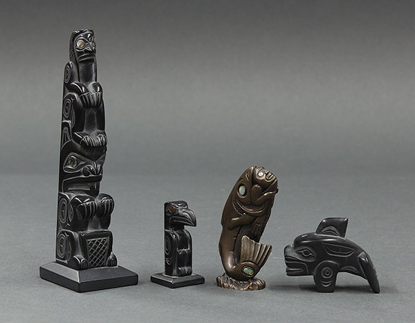 Native American, Northwest Coast figurines: (lot of 4) Native American, Northwest Coast figurines, consisting of a bronze fish with man signed Patty Fawn, three argillite figures including a Haida woman with beaver by Glen Pollard, a smaller bi