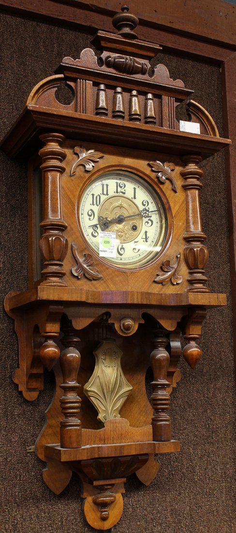 German wall clock: German wall clock, the dial with Arabic markers flanking the central reserve depicting a maiden, accented with floral sprays, the pendulum having stylized accents, each executed in the Art Nouveau tas