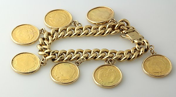 Yellow gold coin charm bracelet: Yellow gold coin charm bracelet featuring one heavy 18K yellow gold curb link bracelet suspending seven, Cinco Peso Republica de Colombia gold coins (very worn), dated 1913, 1919 (2), 1920, 1923, 1924
