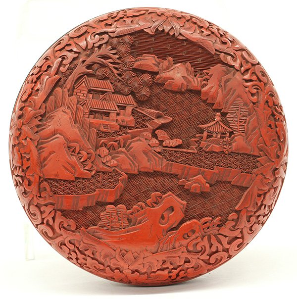 Chinese Cinnabar Circular Box: Chinese cinnabar lacquer circular box, a villa complex and viewing pavillion by the river bank, framed within scrolling tendrils, the underside centered with a floral medallion encircled with petals, 