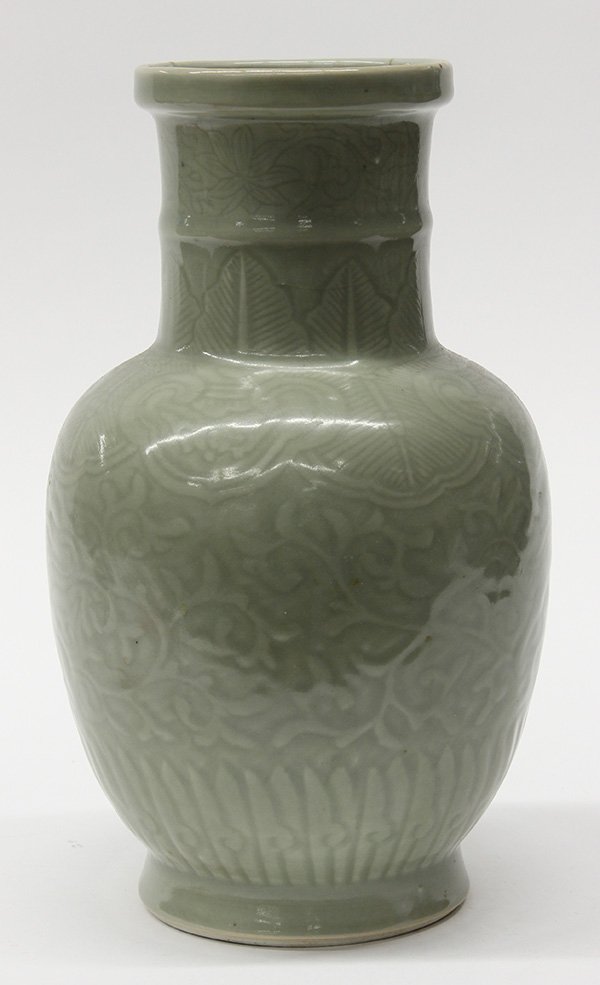 Chinese Celadon Vase, Dragons: Chinese celadon glazed vase, the neck with a band of flowers above stiff leaves, the body molded with meandering pair of dragons amid tendrils, the base with an apocryphal Kangxi mark (hairline cracks