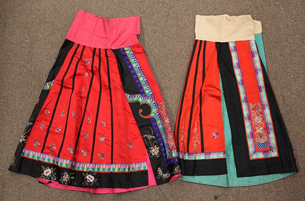 Two Chinese Red Skirts: (lot of 2) Chinese red silk skirts, one embroidered with phoenix and peonies to the main panels; the other with Peking knotted bouquets and antiquities heightened in couching, Provenance: Estate of Re
