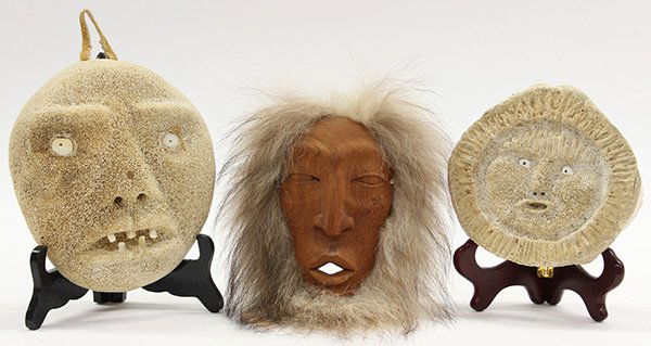 Inuit whale bone carvings: (lot of 3) Two Inuit whale bone carvings of face masks; together with a carved wood face mask with fur Provenance: Property from the collection of the Dr. Mary Anne Warren Estate