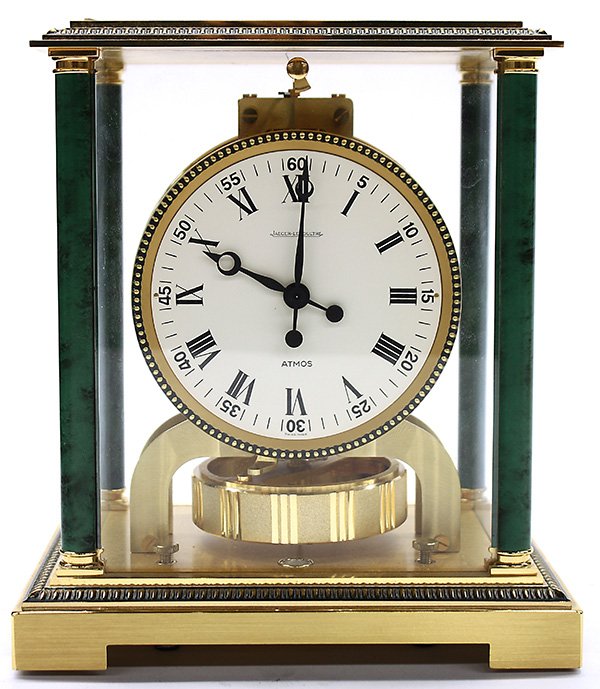 Jaeger Le Coultre Atmos clock: Jaeger Le Coultre Atmos clock, having a brass with glass paneled case, the shallow moulded cornice above the green variegated corner columns, flanking the circular dial with Roman numerals, and rising