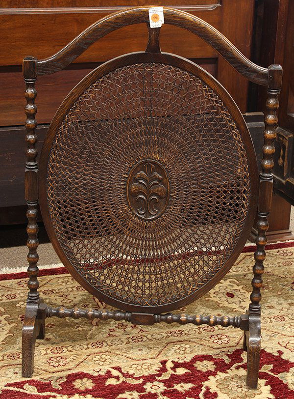 Edwardian oak fireplace screen: Edwardian oak fireplace screen, the shaped top with turned pilasters flanking the oval caned central screen centered with a relief carved medallion, 36"h x 23.5"w