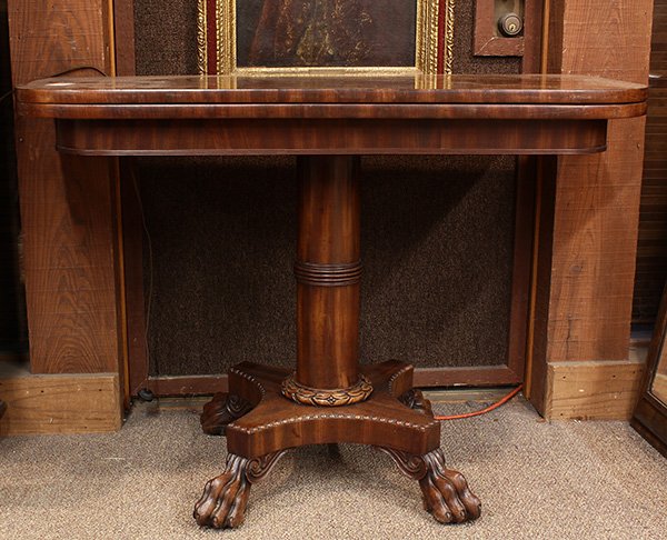 Regency Mahogany games table: Regency Mahogany games table, 19th century, the hinged top opening to a felt playing surface, above the carved columnar standard, continuing to the footed base terminating on paw feet having concealed