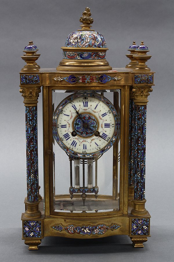 Champleve decorated desk clock: Champleve decorated desk clock, having a gilt bronze and enamel decorated case housing the enamel dial with Roman markers and script Shanghai Hong Kong between winding mechanisms, the exterior flanked