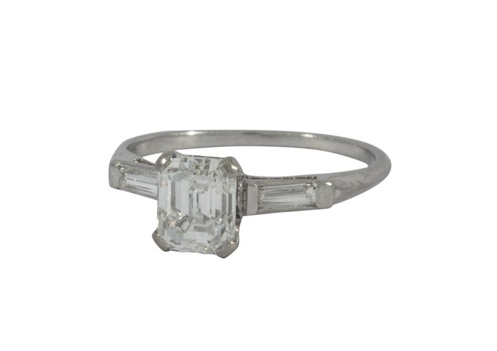 Emerald cut diamond platinum ring: Lady's diamond and platinum ring center set with (1) emerald cut diamond weighing approximately 1.22 cts., set on either side with baguette cut diamonds weighing in total approximately 0.20 ct; 2.2 gr