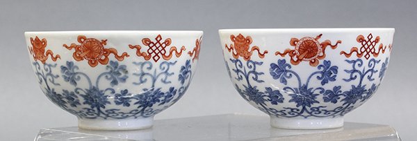 Chinese Red and Blue Enameled Bowls: Pair of Chinese iron red and blue enameled bowls, each featuring the Eight Buddhist Symbols in red above lotus scrolls decorated in blue enamels, the base with an apocryphal Qianlong mark, 4"w