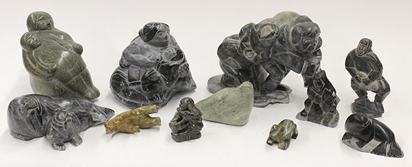 Inuit stone carvings: (lot of 12) Inuit stone carvings, including human and animal figures, the collection contains a large figure of hunters in dark stone, attributed to Jusipi Nalatuja Qaqutu, Canada, retaining original 