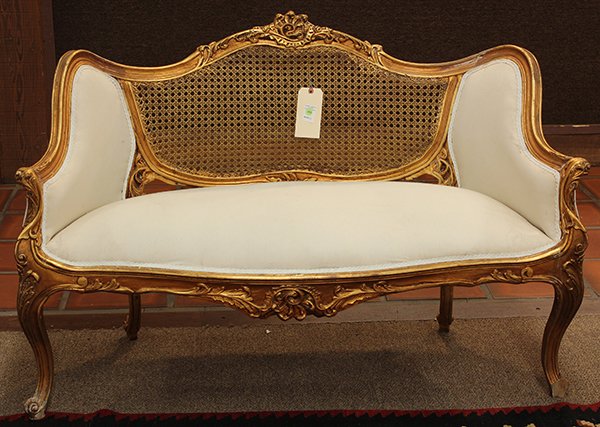 Pair of Rococo style giltwood settees: Pair of Rococo style giltwood settees, the serpentine back having caned central reserves flanked with two padded suppports, surmounted with a scroll carved crest and rising on cabriole legs, 34"h x 51