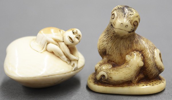 Japanese Two Ivory Netsuke: (lot of 2) Japanese ivory netsuke: a kappa (river imp) with a hand stuck in the clam shell, signature marked; and a dog with a puppy, largest: 1.5"l