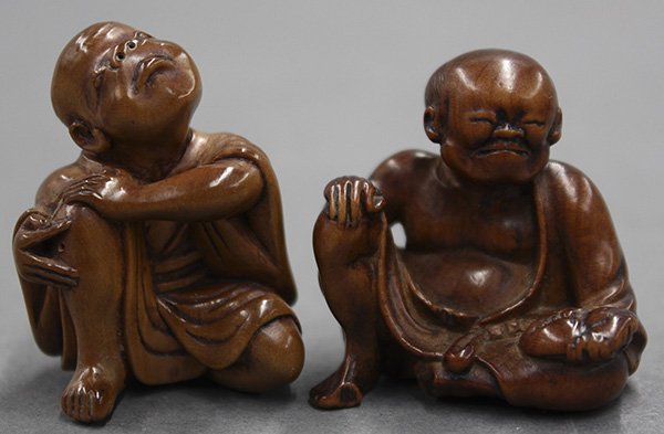 Japanese Two Wooden Netsuke, Edo epriod: (lot of 2) Japanese wooden netsuke, a pouting boy with one knee raised; and a man holding a mask, marked with an illegible signature, largest: 1.5"l