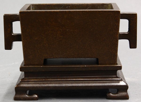 Chinese Bronze Rectangular Censer: Chinese patinated bronze censer and stand, of rectangular form with angular handles, raised on short supports, the base marked 'shi gu zhi bao', with a fitted bronze stand, stand: 5.5"w