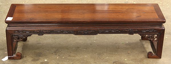 Chinese Narrow Low Table, Bats: Chinese hardwood narrow low table (kangzhuo), 20th century, the rectangular top fronted by the apron carved with bats and clouds, the supports with scroll terminals and joined to side stretchers (repa