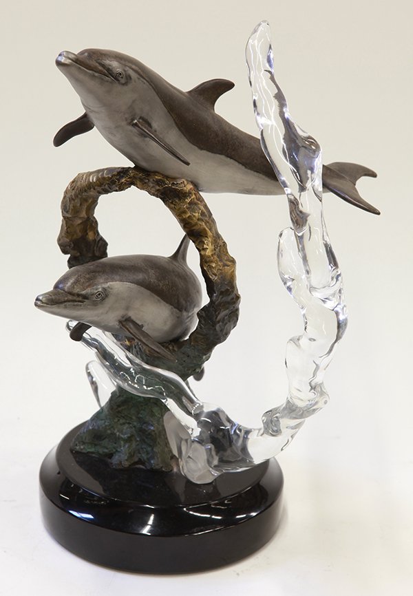 'Splish Splash, a dolphin statue by Kitty Cantrell: 'Splish Splash' dolphin statue by Kitty Cantrell for Genesis, executed in brass, acrylic, and marble, and depicts two dolphins swimming through a water spray, rising on a black marble plinth, titled a