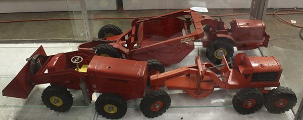 Pressed steel toy tractors: (lot of 3) Pressed steel toy tractors, circa 1950, consisting of a Doepke Model Toys tractor and Heiliner earth mover, 30"l x 9"w; a Ny-Lint road grader, 18"l x 8"w; and a Ny-Lint payloader, 12"l x 7"
