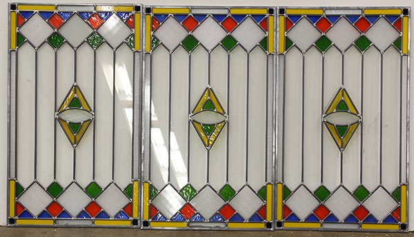 (lot of 5) Pop Art style stained glass window panels: (lot of 5) Pop Art style stained glass window panels, having repeating geometric designs executed in yellow, blue, green and red, 34.5"h x 20"w. Provenance: Original designs from the Gabilan Glass Com