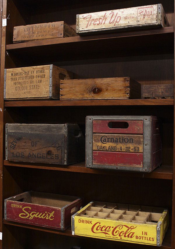 Four shelves of wood advertising crates: (lot of 9) Four shelves of wood advertising crates, including a Coca Cola bottle crate, (2) 7-UP crates, a Squirt crate, a Carnation crate from Oakland CA, a Star Egg Carrier, and a Golden State crate
