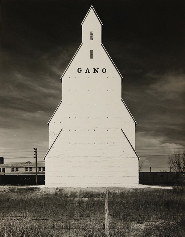 Photograph, Wright Morris, Gano Grain Elevator (1940): Wright Morris (American, 1910-1998), "Gano Grain Elevator (1940)," gelatin silver print, signed in pencil verso, later reprint, sheet (unframed): 14"h x 11"w, overall (with mat): 20.25"h x 16"w. Prove