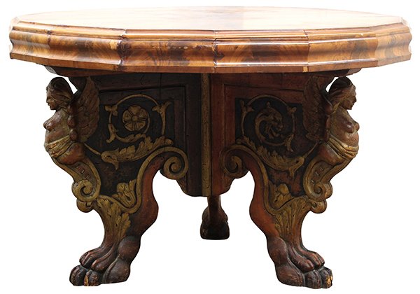 Queen Anne style carved walnut dining table: Victorian Renaissance Revival center table, executed in highly figured mahogany circa 1885, having a top of octagonal form with a molded apron, surmounting the carved tripod base accented with figureh