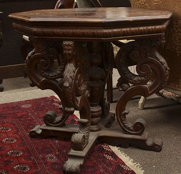 Renaissance style occasional table: Renaissance style occasional table, circa 1900, having an octagonal top surmounting the relief carved supports accented with figural caryatid capitals, and rising on an X form base terminating on insw