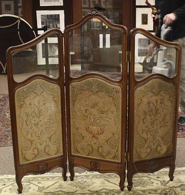 Louis XV style three panel fire screen: Louis XV style three panel fire screen, first quarter 20th century, executed in walnut with shaped crests, each panel having a glass and a needlepoint insert to one side and velvet inserts verso, risi