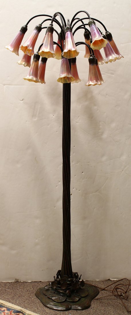 Art Nouveau style patinated bronze lily floor lamp: Art Nouveau style patinated bronze lily floor lamp, the eighteen light fixture with favrile style shades marked Lundberg (Lundberg Studios), each having an iridescent surface, and rising on a naturali